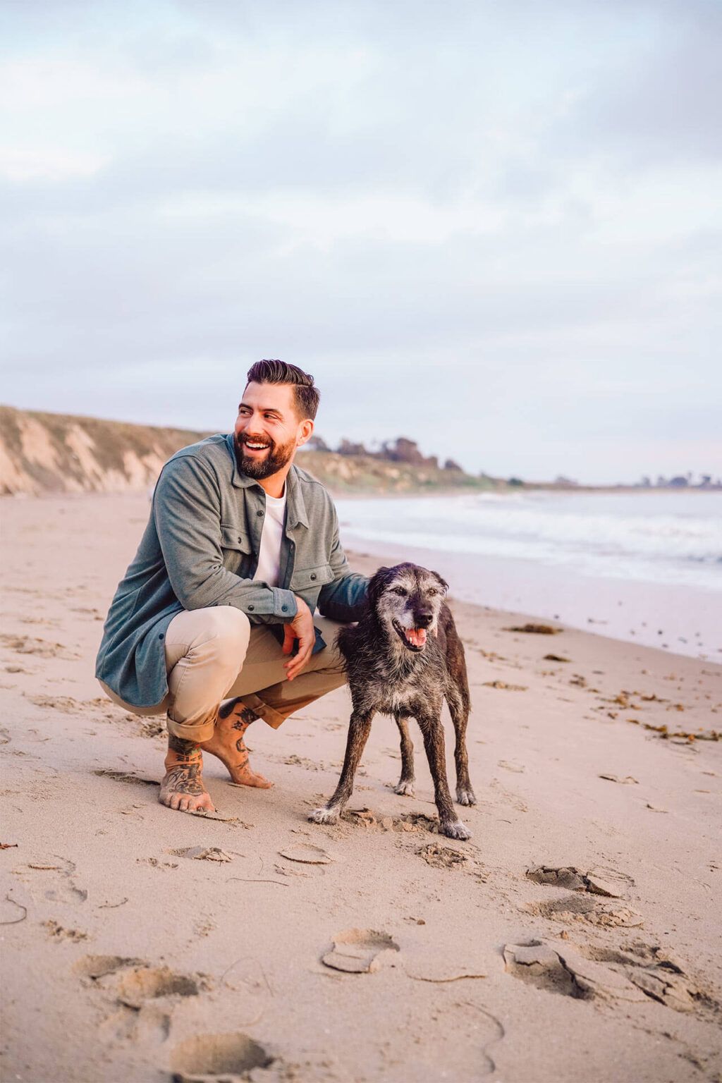 a man with his dog on the beach