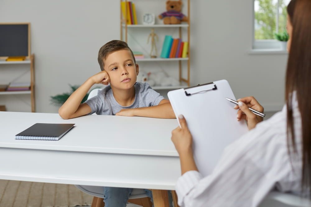 Portrait of mother talking to male psychologist about her teenage boy and phone addiction