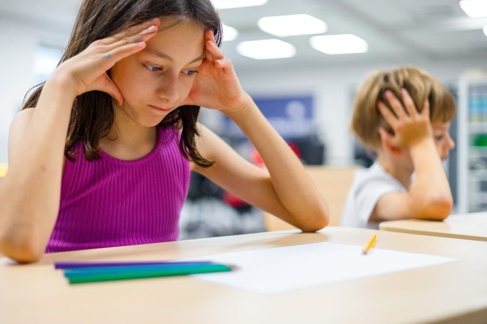 Children showing signs of difficulty concentrating during a classroom activity. Suitable for themes of ADHD, attention problems