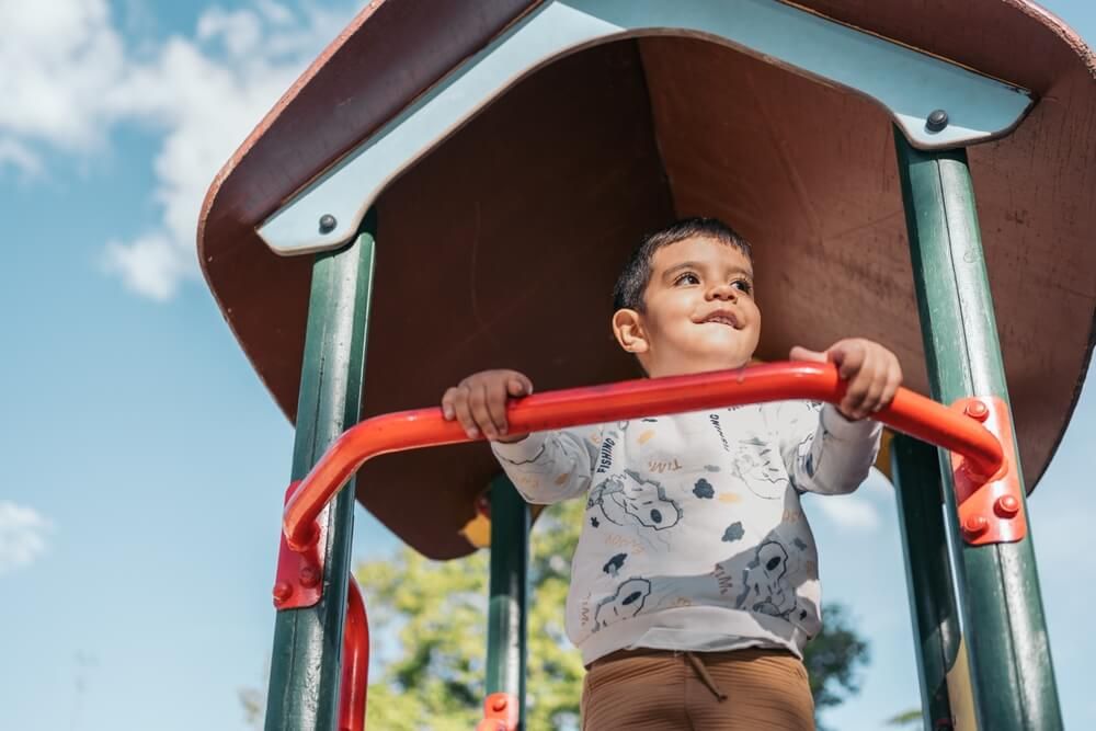 Smiling young boy enjoys outdoor fun on a sunny day at the playground