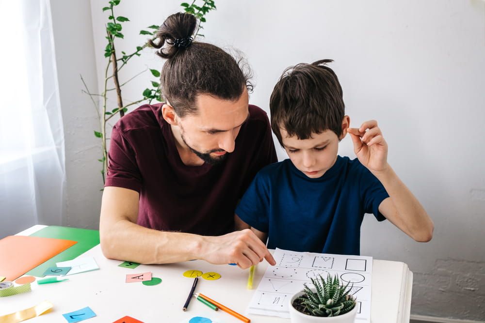 Man teacher teaches autism boy during therapy. Autism, asperger child lifestyle concept