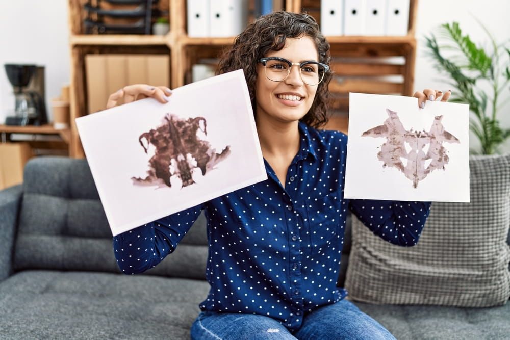 Young latin woman having psychology session doing rorscharch test at psychology center