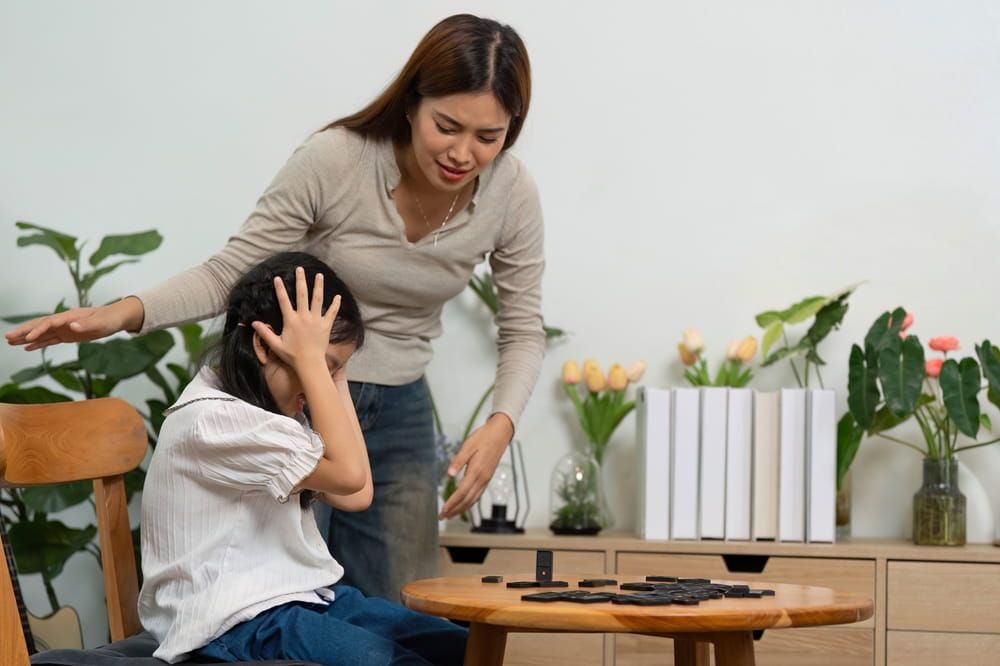 Parenting and Playtime. A mother comforts her child after a game mishap, fostering emotional resilience.