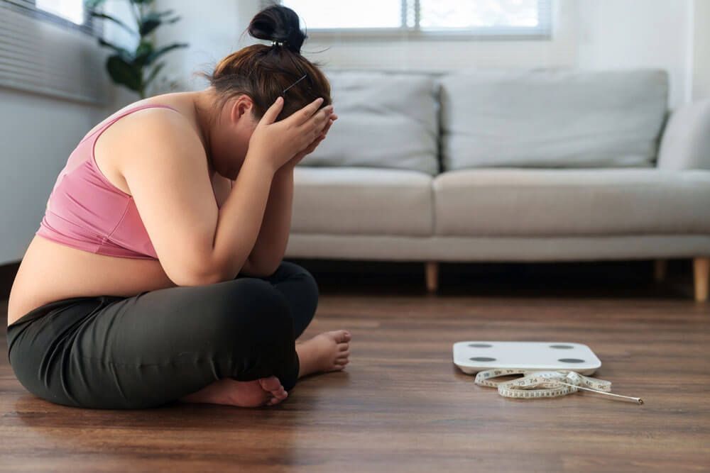 Stressful Asian overweight woman sad of dieting Weight loss fail.