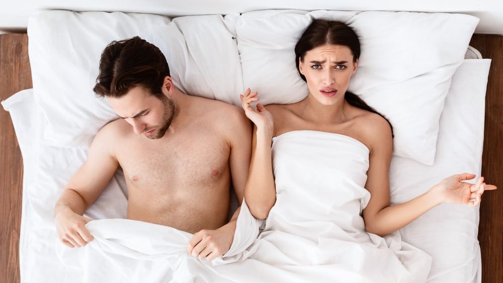Displeased Girlfriend Lying Near Boyfriend With Erectile Dysfunction In Bed
