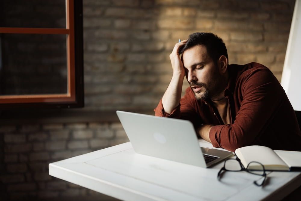 Sleepy office worker feeling drained and exhausted during a busy workday.