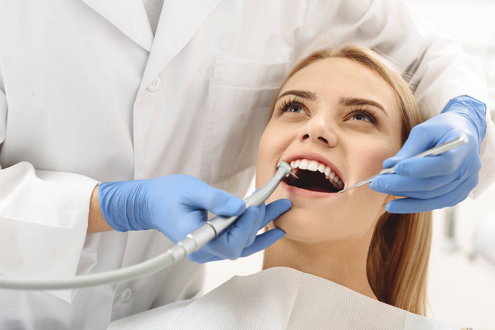 Dentist starting common operation of cleaning female mouth