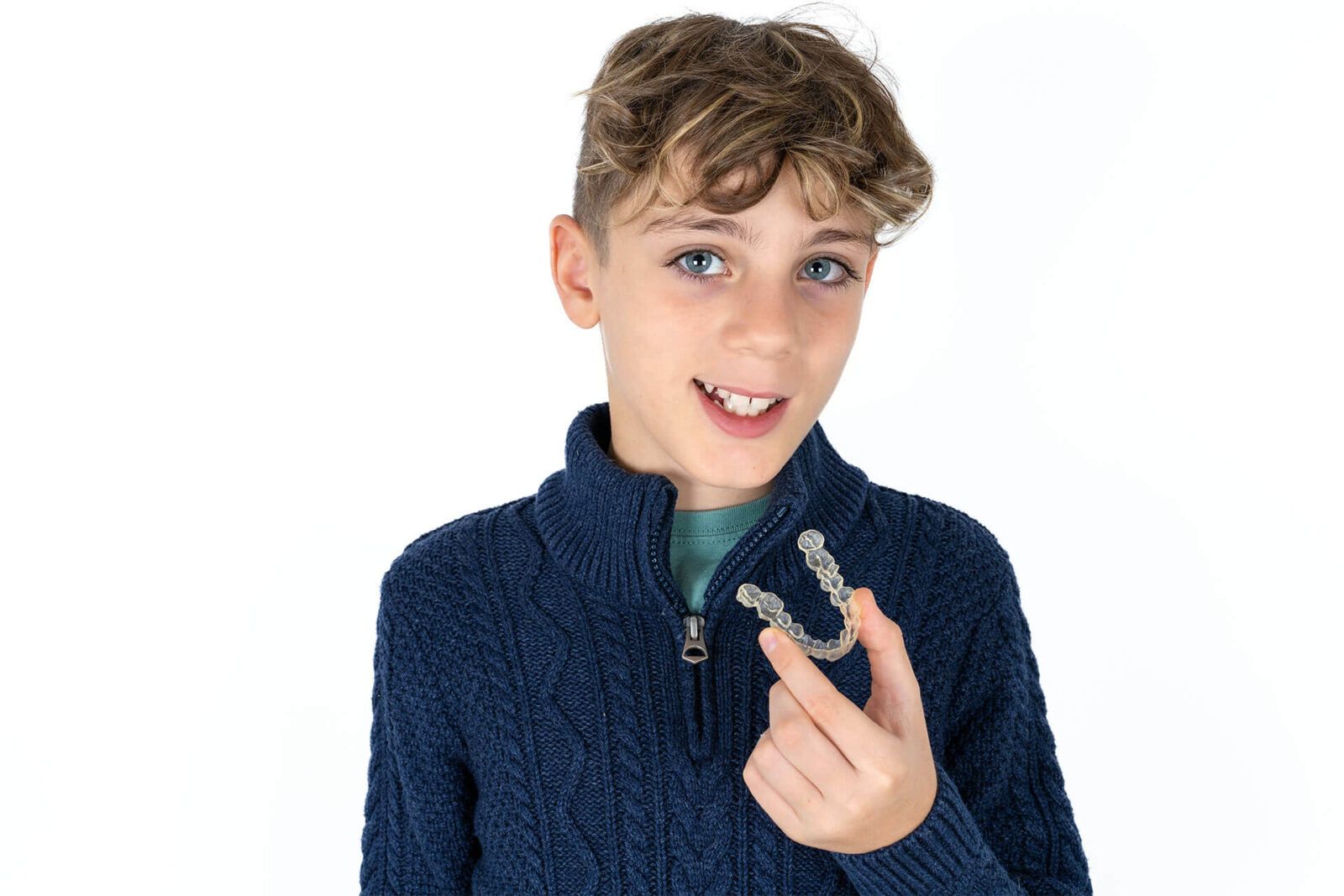 Happy teen boy holding an invisible aligner ready to use it