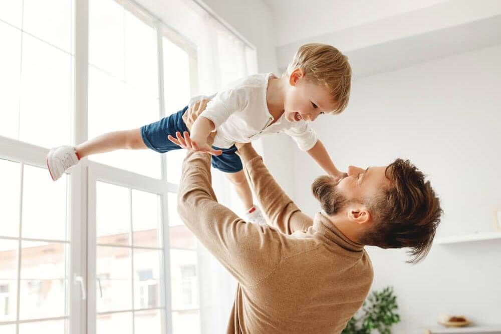 a father lifting his child at home
