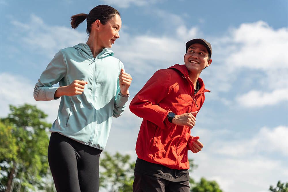 Mature female and male running outdoors
