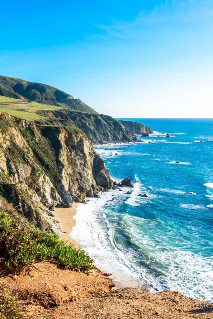 Vertical view of the steep coastal cliffs and hidden beach in Big Sur, California