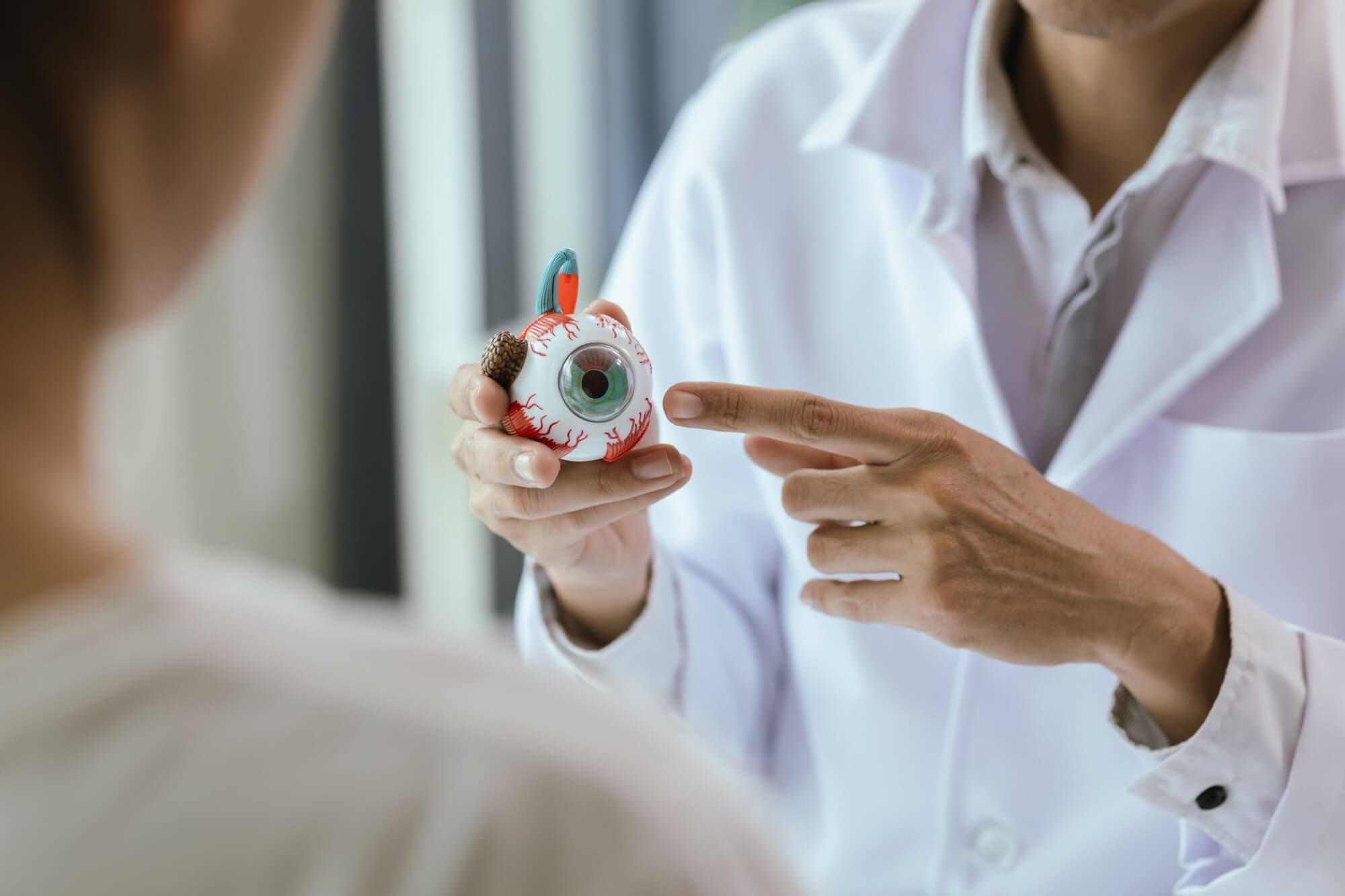 An elderly Asian woman visits an ophthalmologist at a clinic for an eye exam
