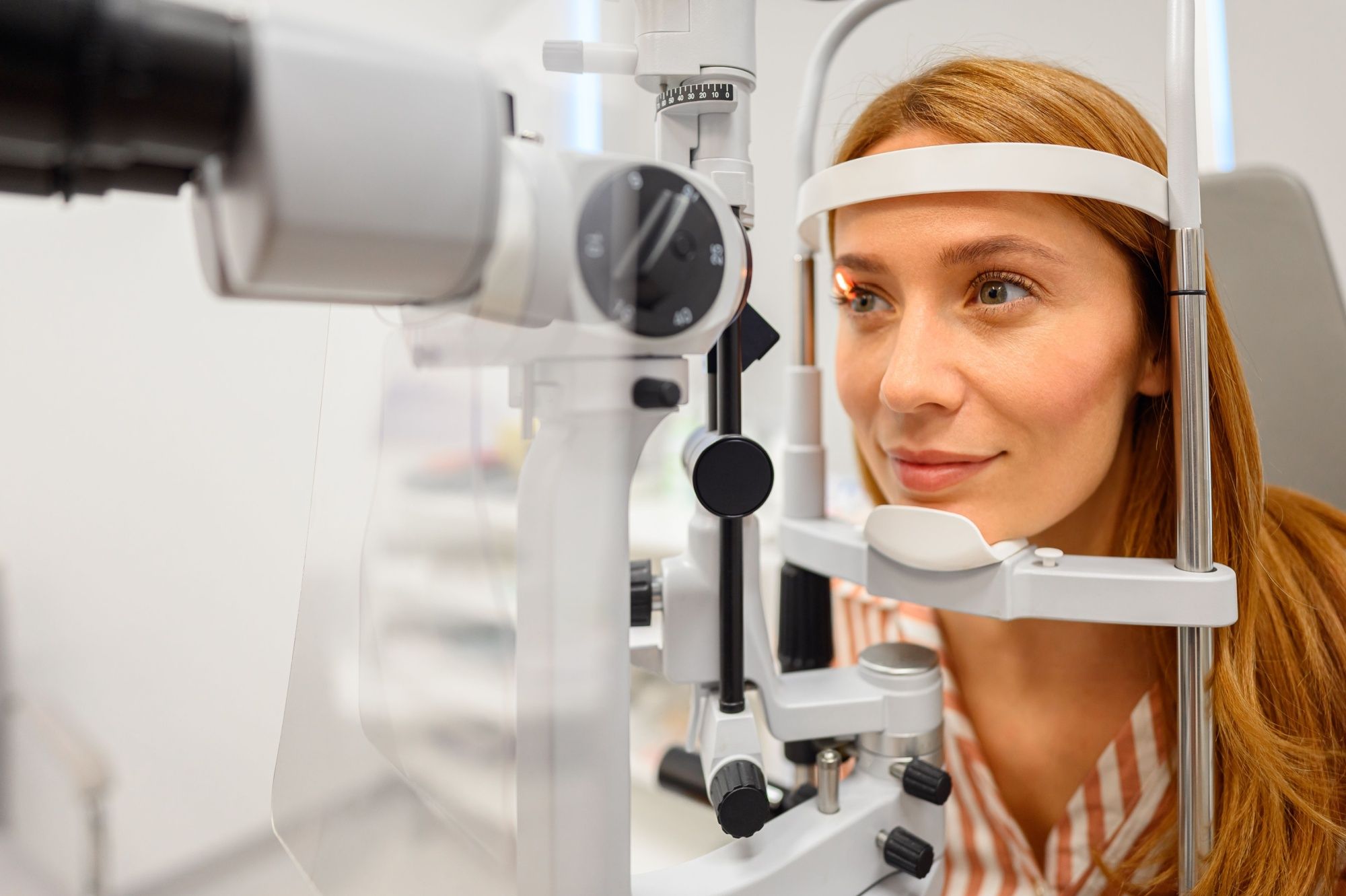Female patient undergoing detailed eye examination with slit lamp light