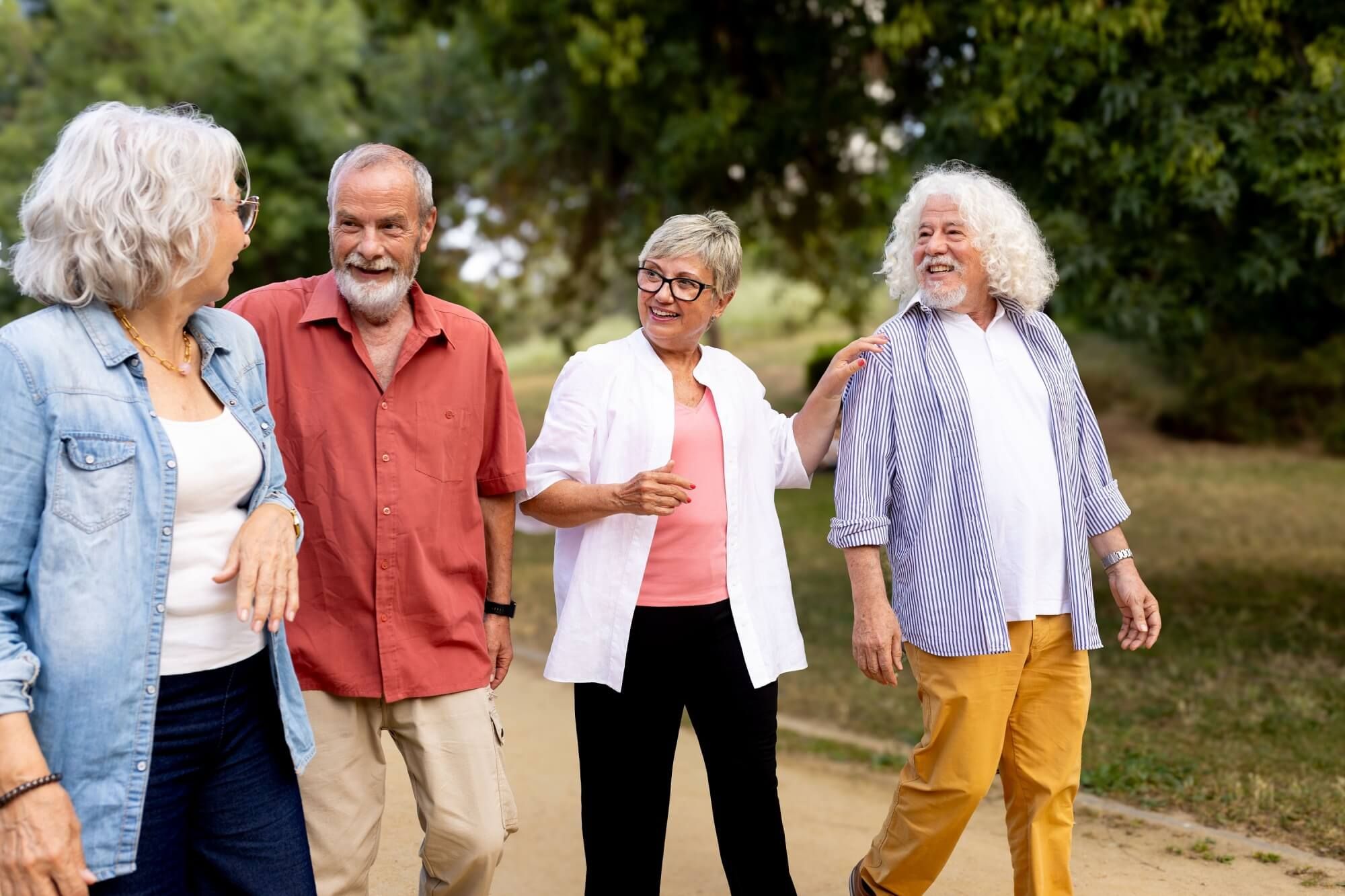 Group of seniors enjoying a leisurely walk, friendship, and conversation outdoors