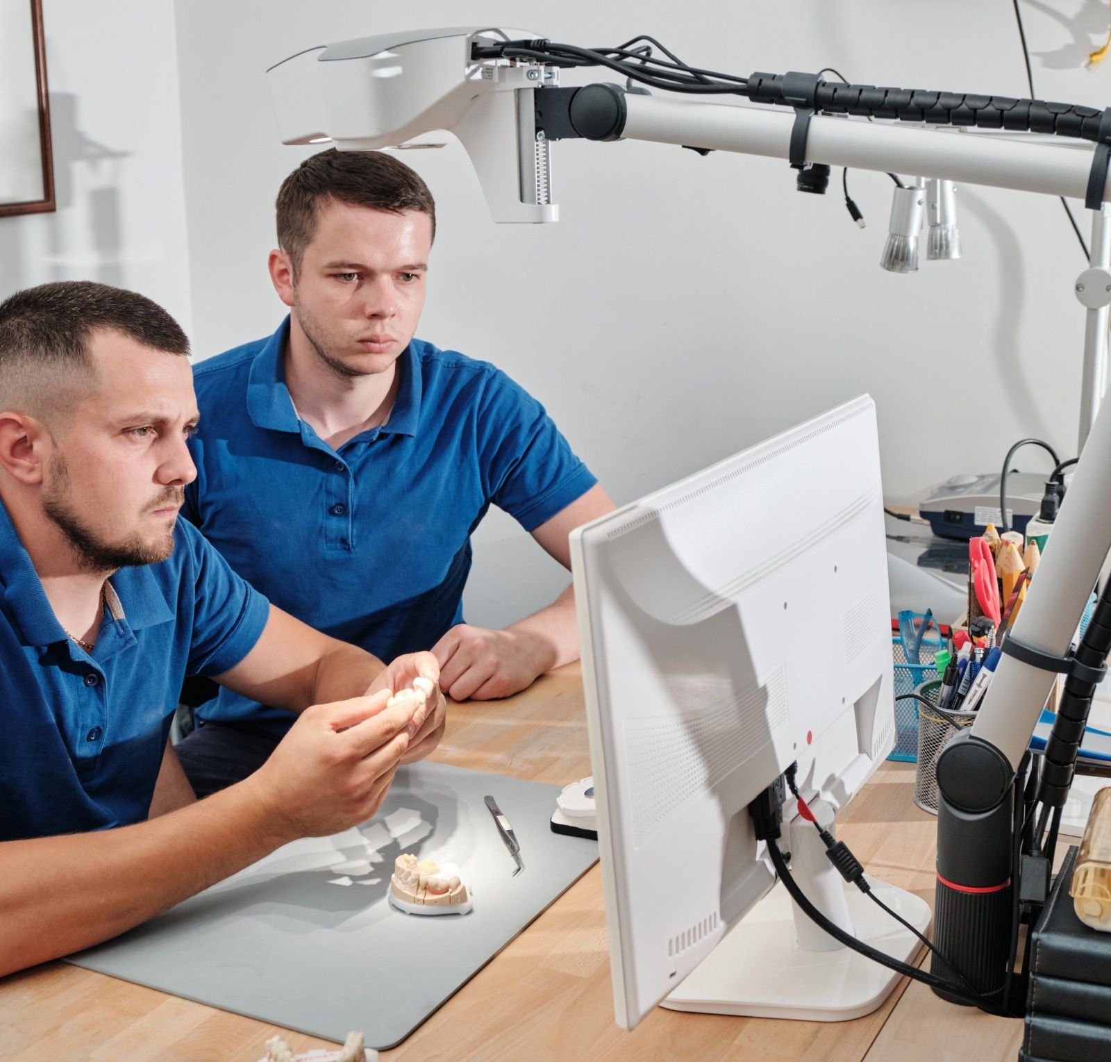 Dental technicians producing dental prosthesis under the microscope. The concept of prosthetics and implantology.