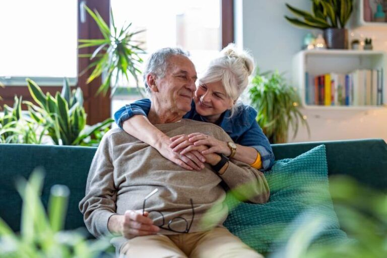 Portrait of a happy senior couple sitting on sofa at home