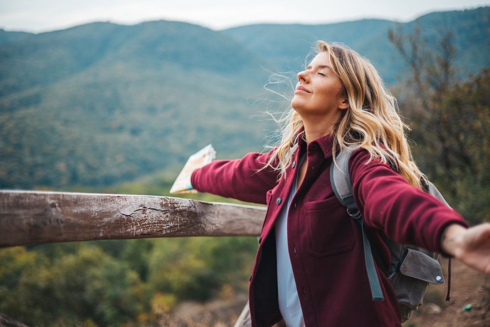 Woman contemplating a beautiful landscape. Young woman breathing pure air in a forest
