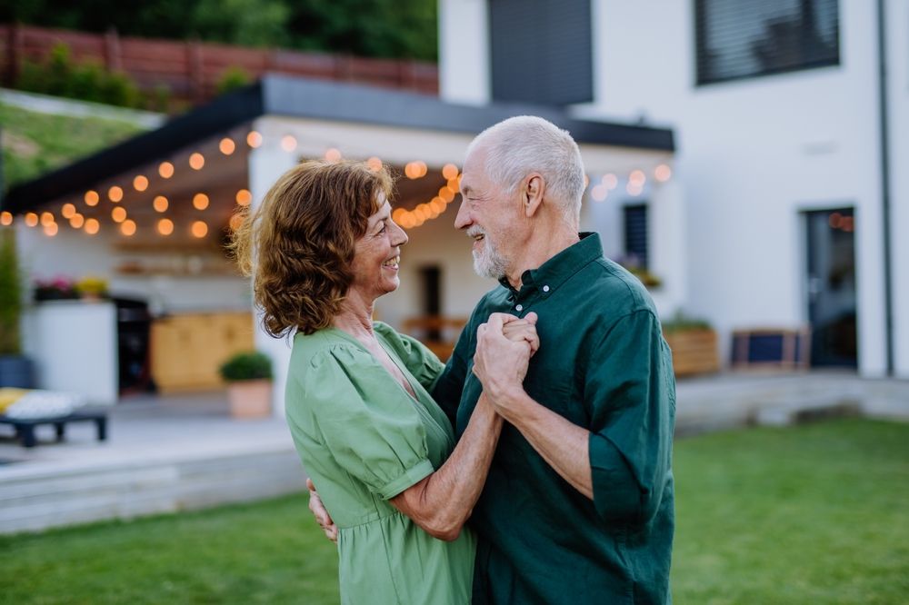 Senior Couple Dancing Together in a Sunny Garden During Warm Afternoon