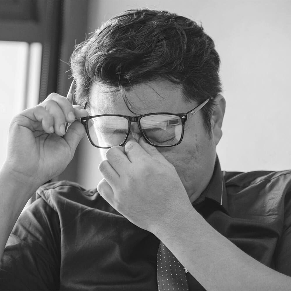 man sitting wood desk feeling negative depression