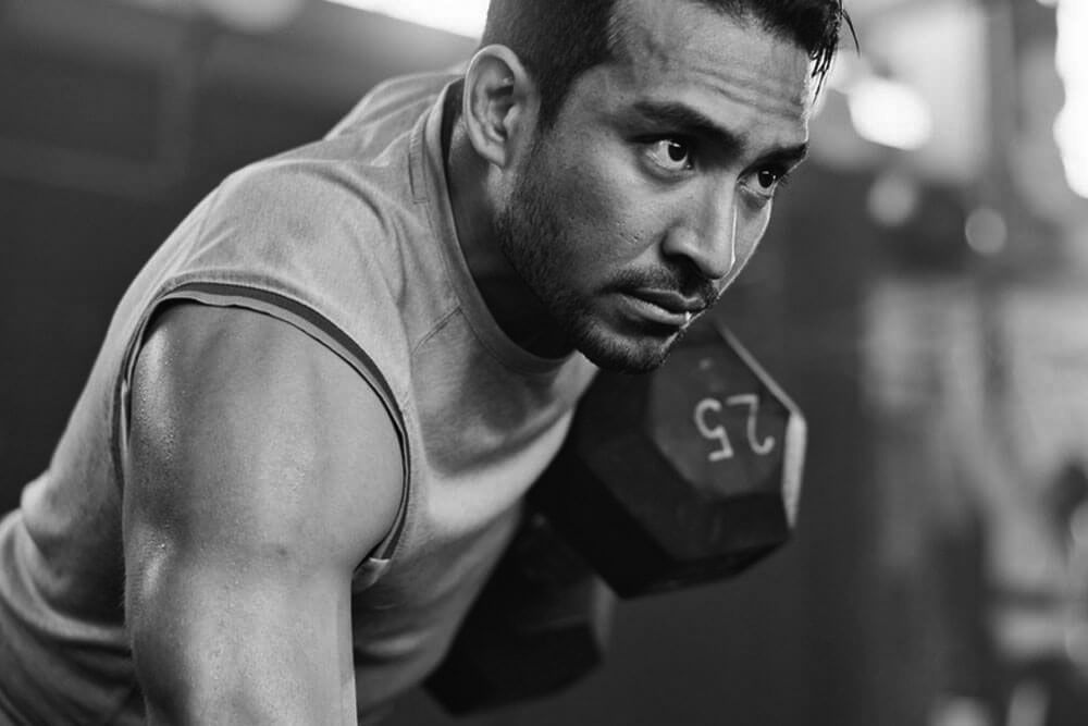 Serious man, dumbbell and weightlifting in workout, exercise or fitness at indoor gym