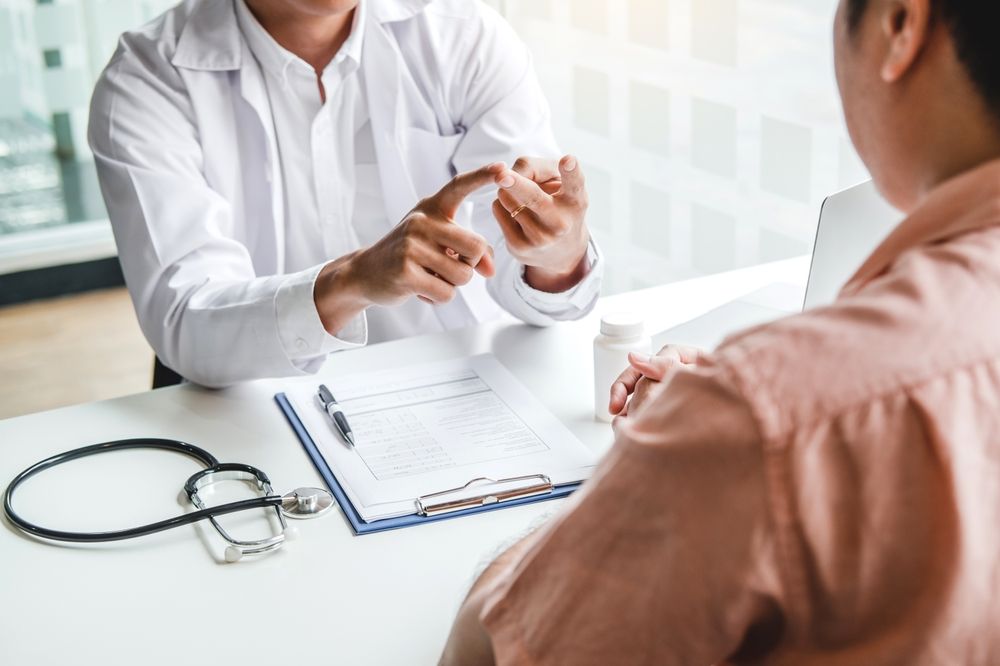 Doctor and patient consulting and diagnostic examining sit and talk