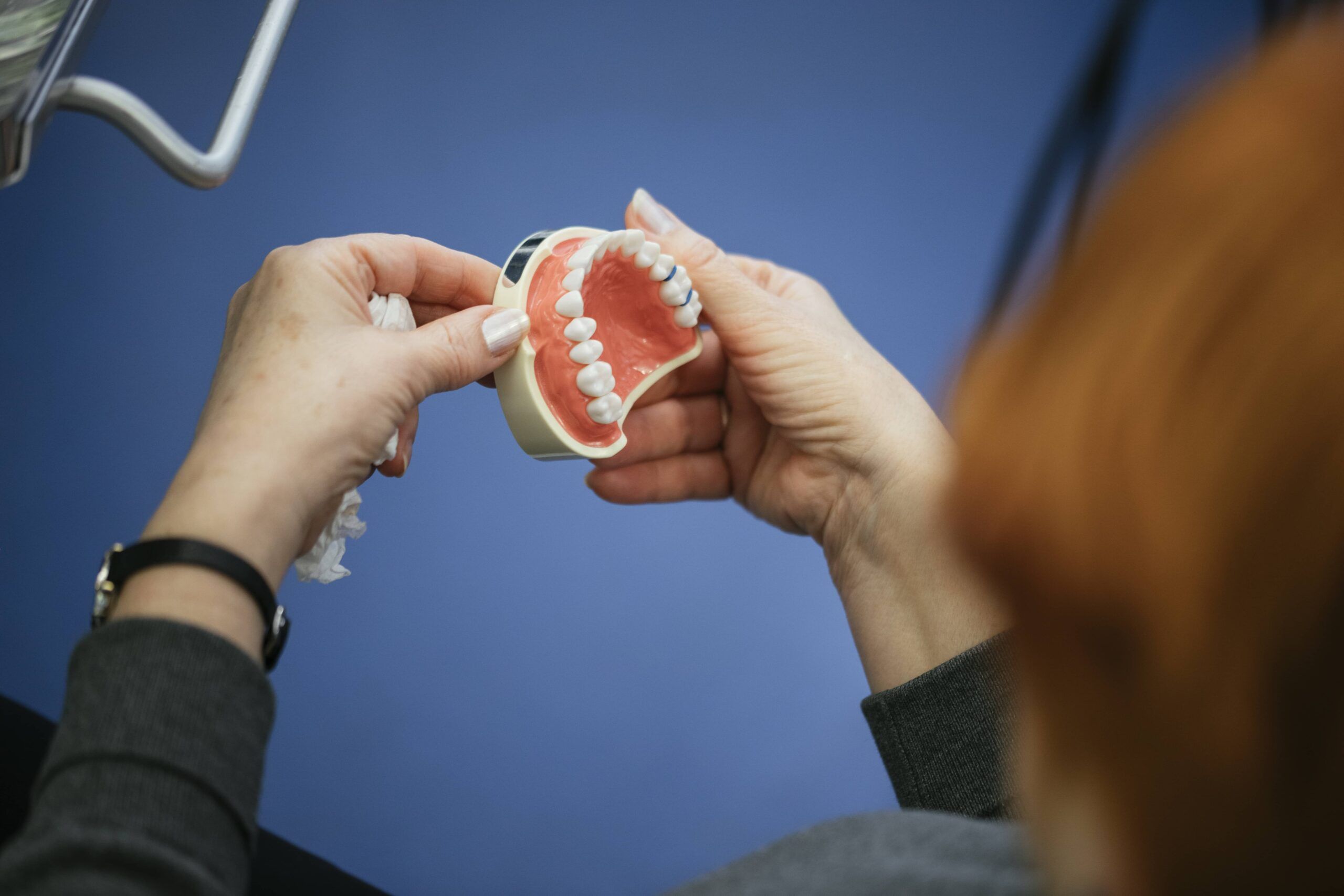 Senior Woman Sitting In A Chair Looking At The Dentures