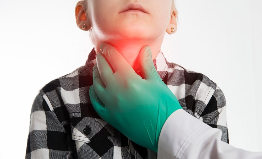 The hand of an endocrinologist palpates the thyroid gland