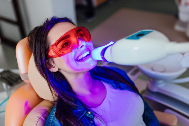 Teeth whitening for woman. Bleaching of the teeth at modern dentist clinic