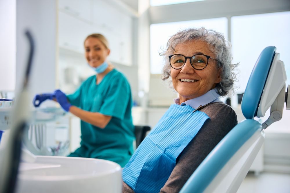 Happy senior woman during dental appointment at the dentist looking at camera.