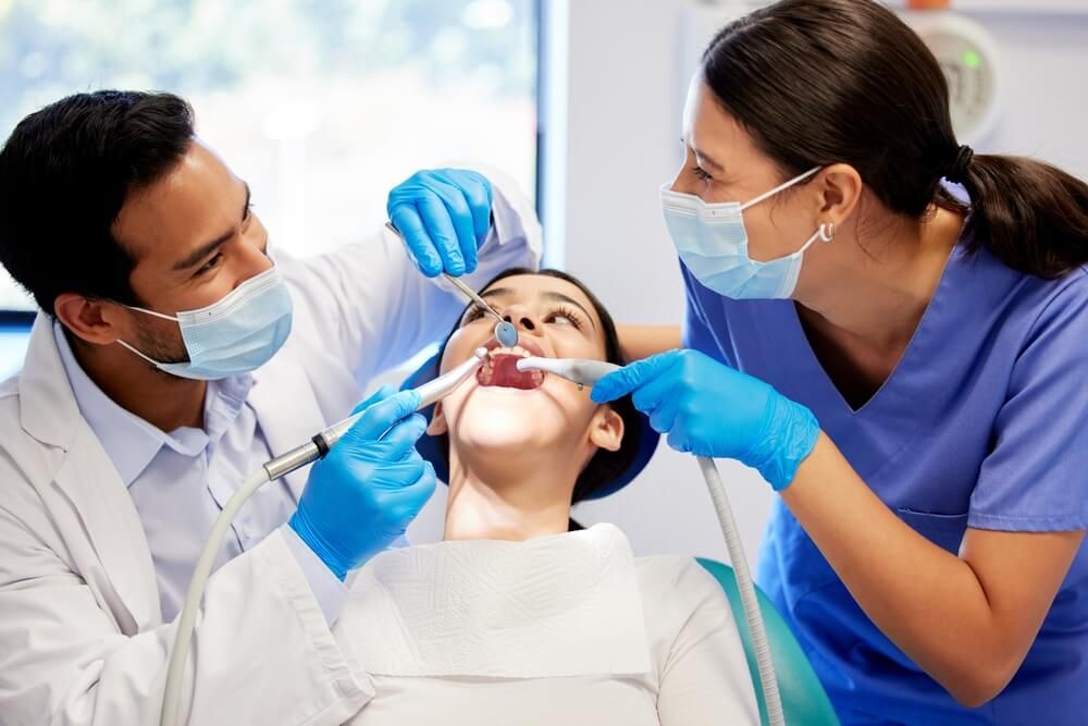 Dentist, team and patient in clinic with equipment for consultation, oral hygiene or medical procedure.