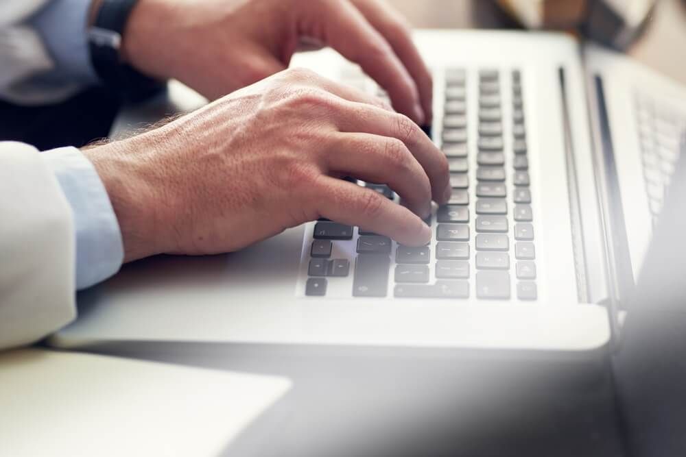 Medical, doctor and hands on laptop in clinic for research, wellness investigation or report for healthcare