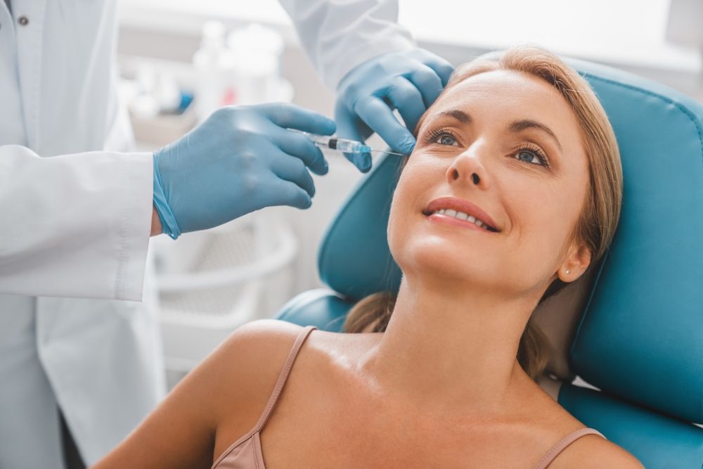 Beautiful middle aged woman get injection in clinic. Cosmetology and beauty concept