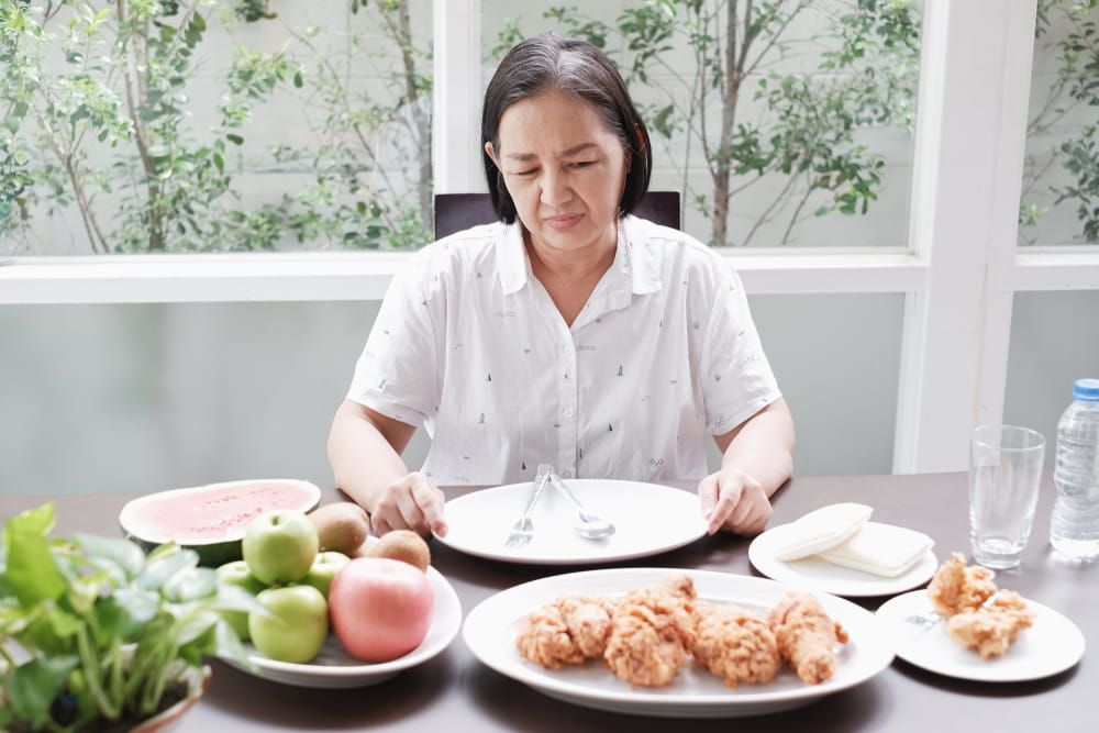 Asian Senior woman bored with food because indigestion