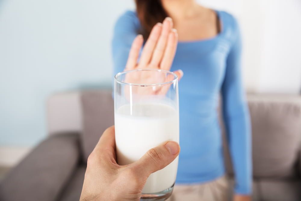 Close-up Of A Woman Rejecting Glass Of Milk At Home