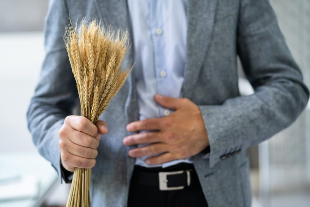 Celiac Disease And Gluten Intolerance. Women Holding Spikelet Of Wheat