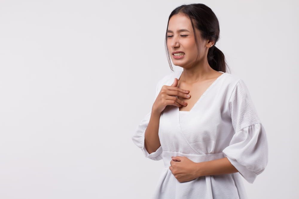 sick stressed woman with acid reflux, gerd symptoms