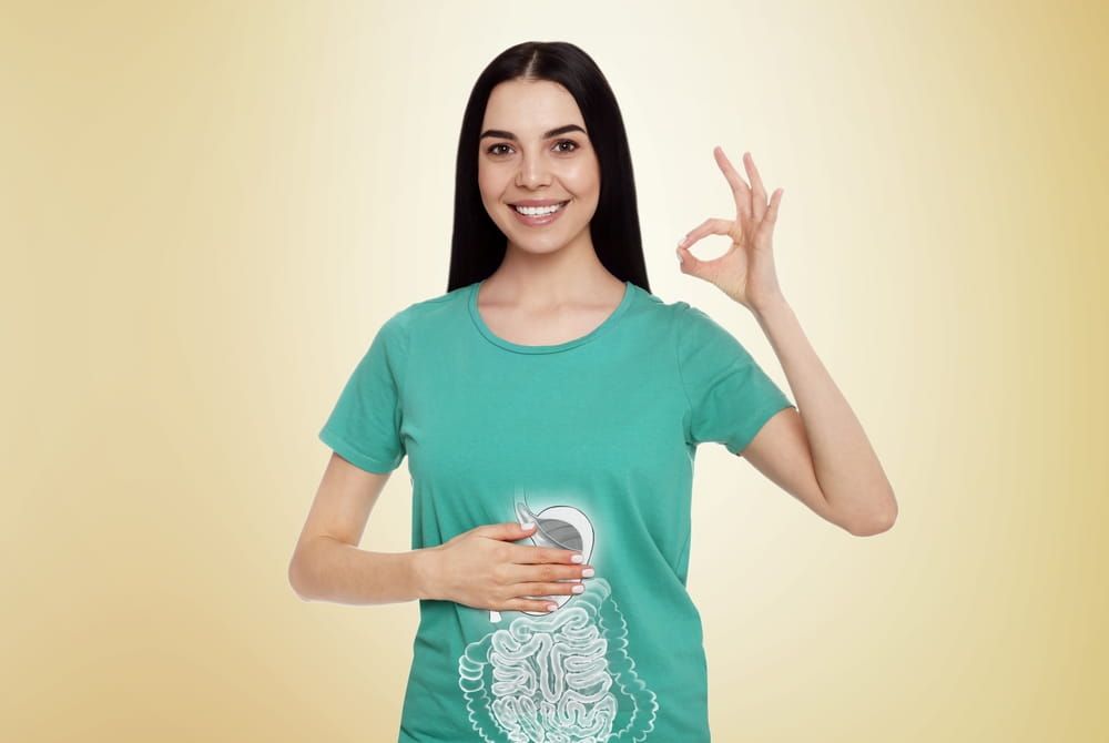 Happy woman with healthy digestive system on light