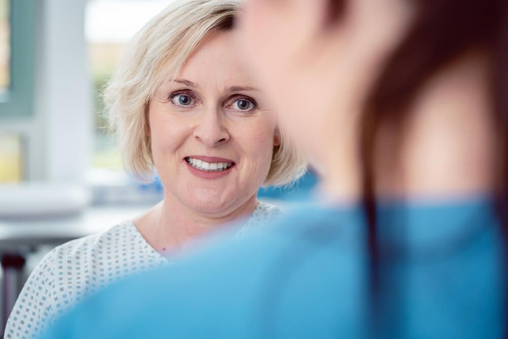Nurse preparing patient for the coming surgery by explaining what will happen
