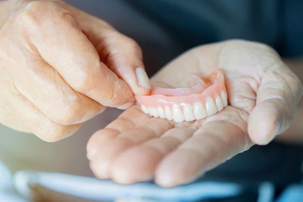 Close-up in the hand of a pensioner removable dentures. Stomatology