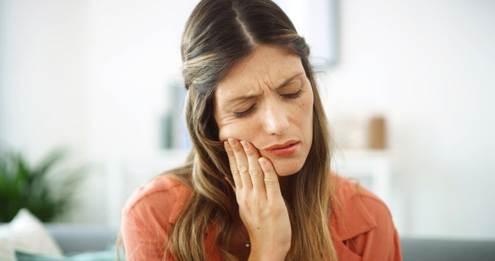 Woman, sore mouth and toothache at house from dental cavity, tooth extraction and gum infection