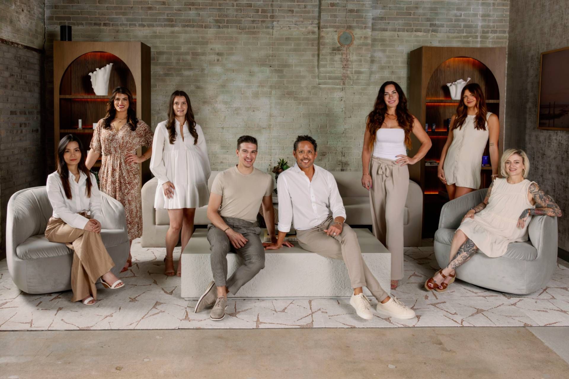 Group portrait of eight Arvé Aesthetics team members in the practice lobby.