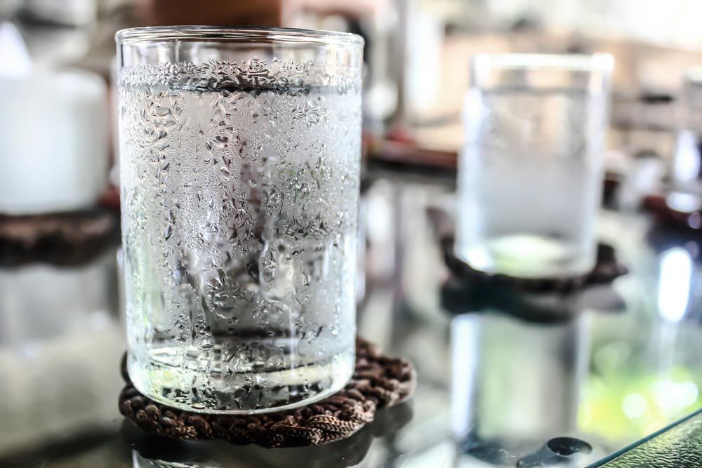 a chilled glass of water with heavy condensation on its exterior