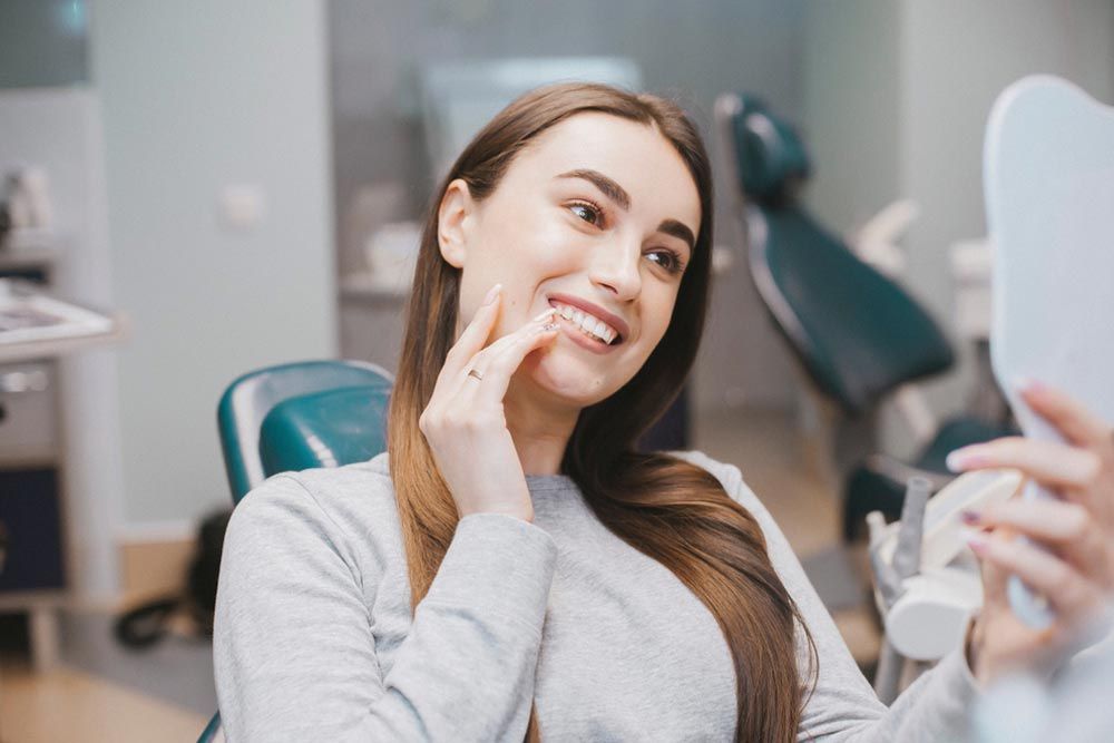 a person looking in a mirror at a dental clinic