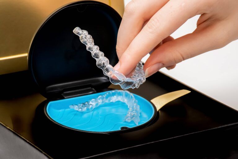 Transparent aligners in a box. Invisible braces. Clear teeth straighteners. Clear plastic bracers