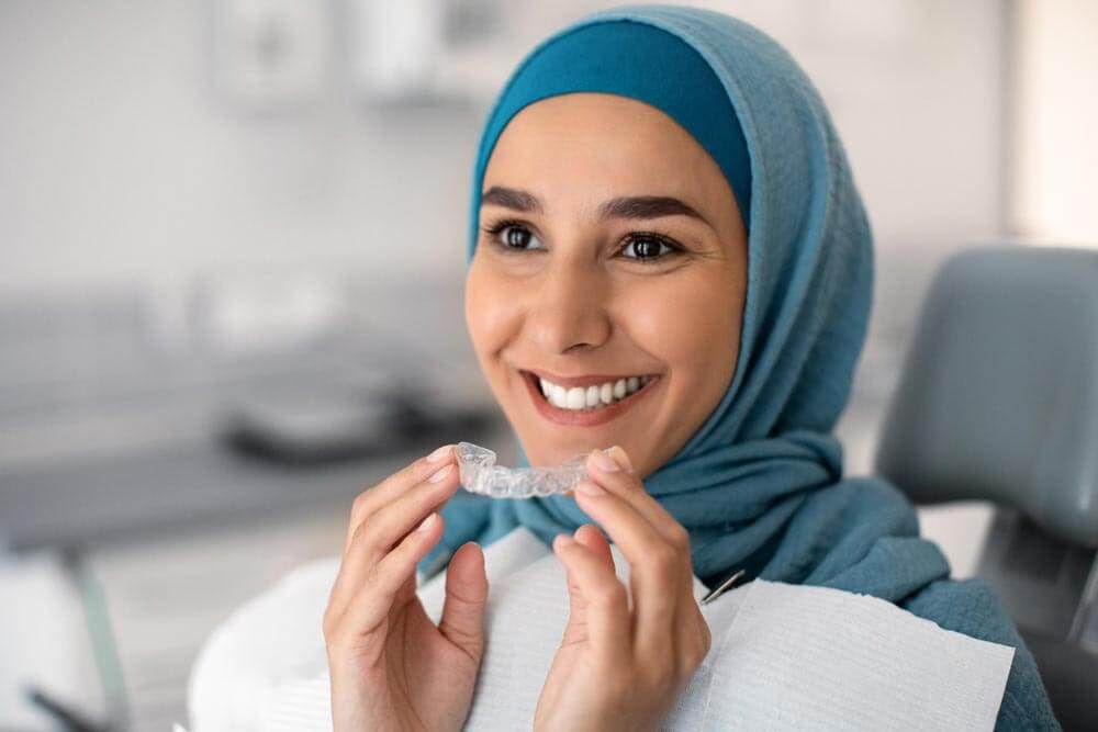 a person holding a clear dental aligner