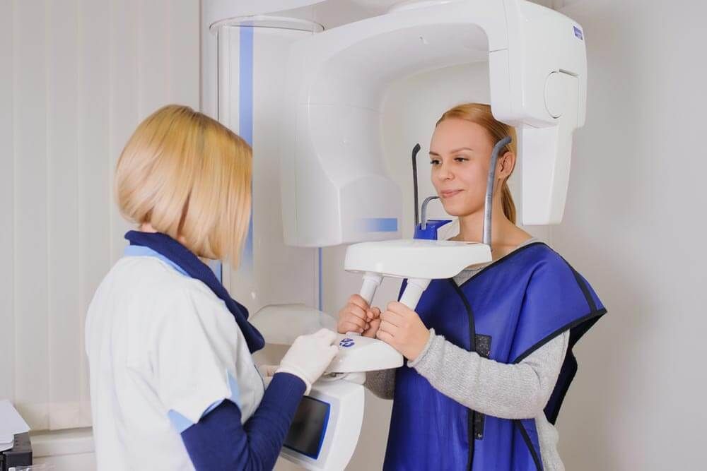 a panoramic dental X-ray machine being used to take a comprehensive image of a patient's mouth and jaw.