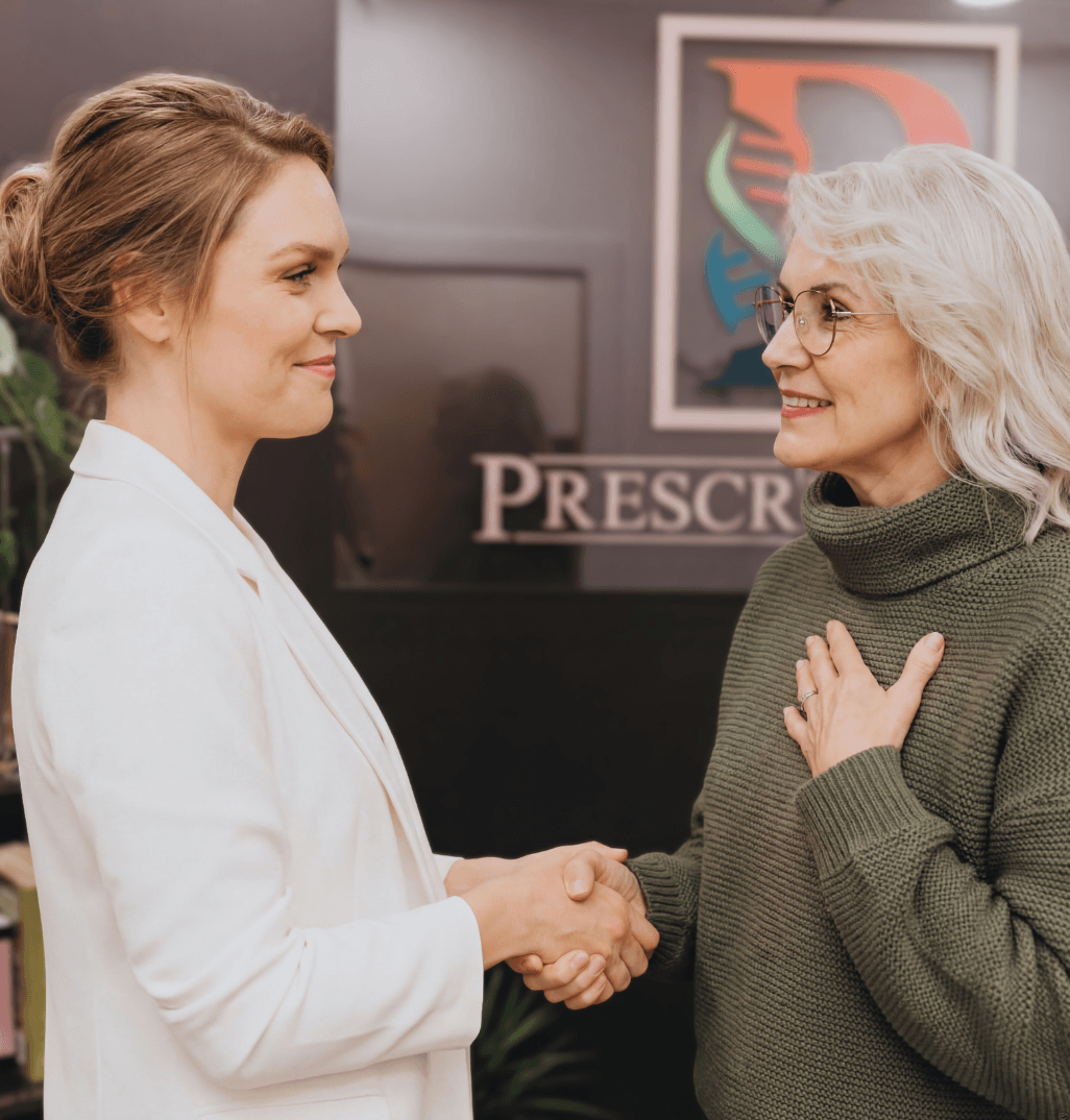 Senior women smiling and shaking hands with doctor
