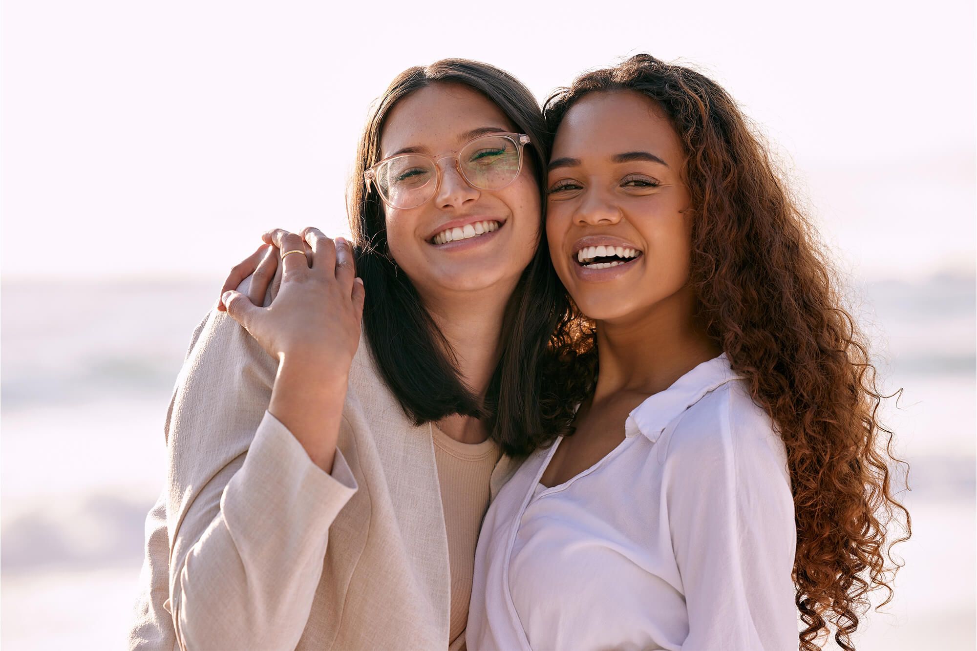 Portrait of two young woman smiling at sea