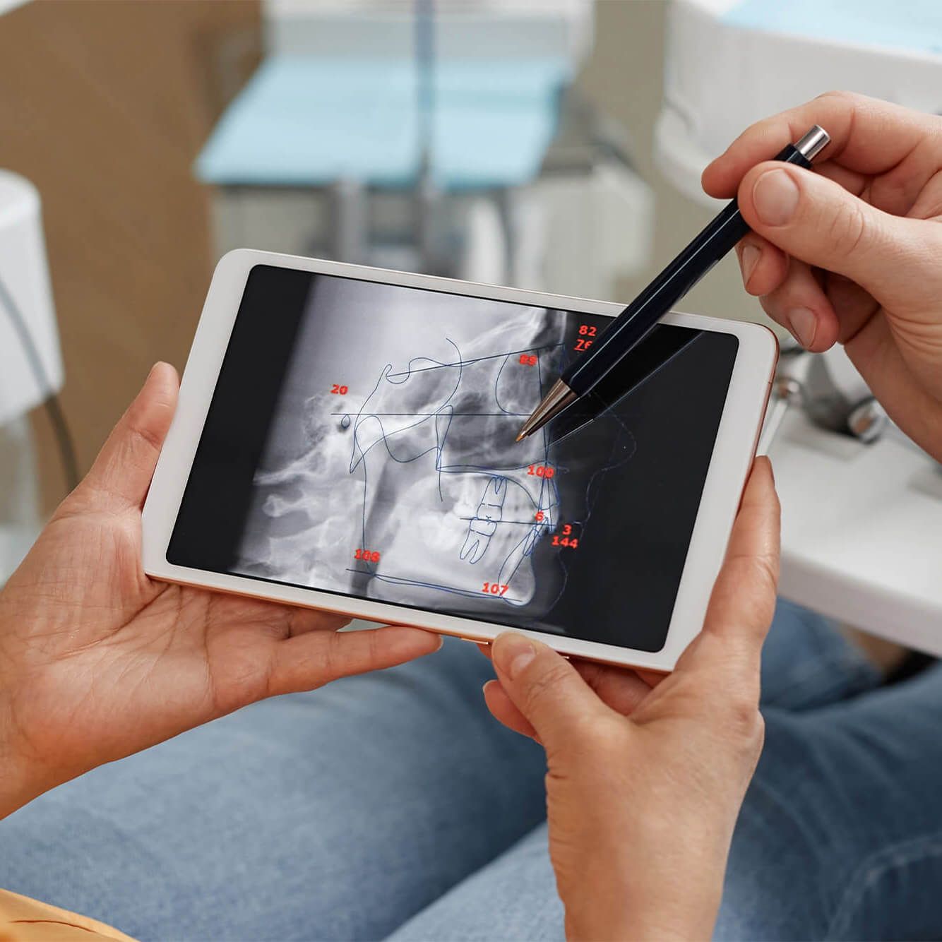 dentist showing patient dental x-ray on tablet