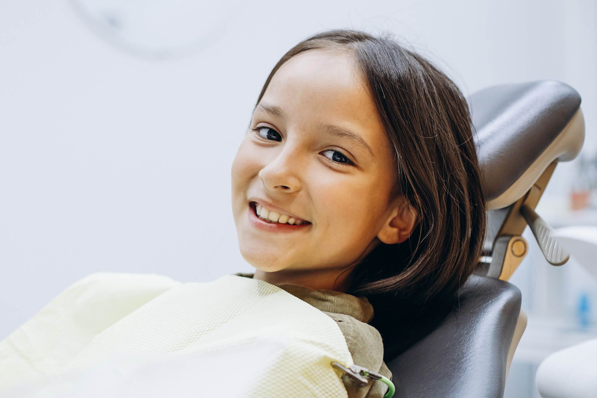 young girl sitting on a dental chair